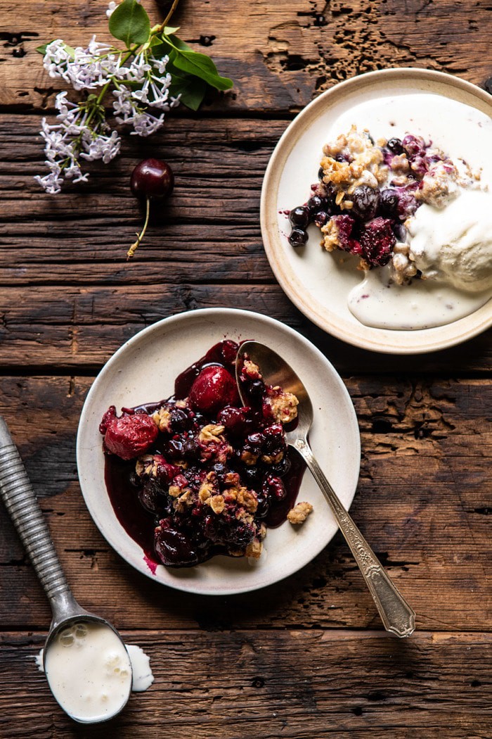 Buttery Cherry Berry Skillet Crisp on 2 serving plates with ice cream 