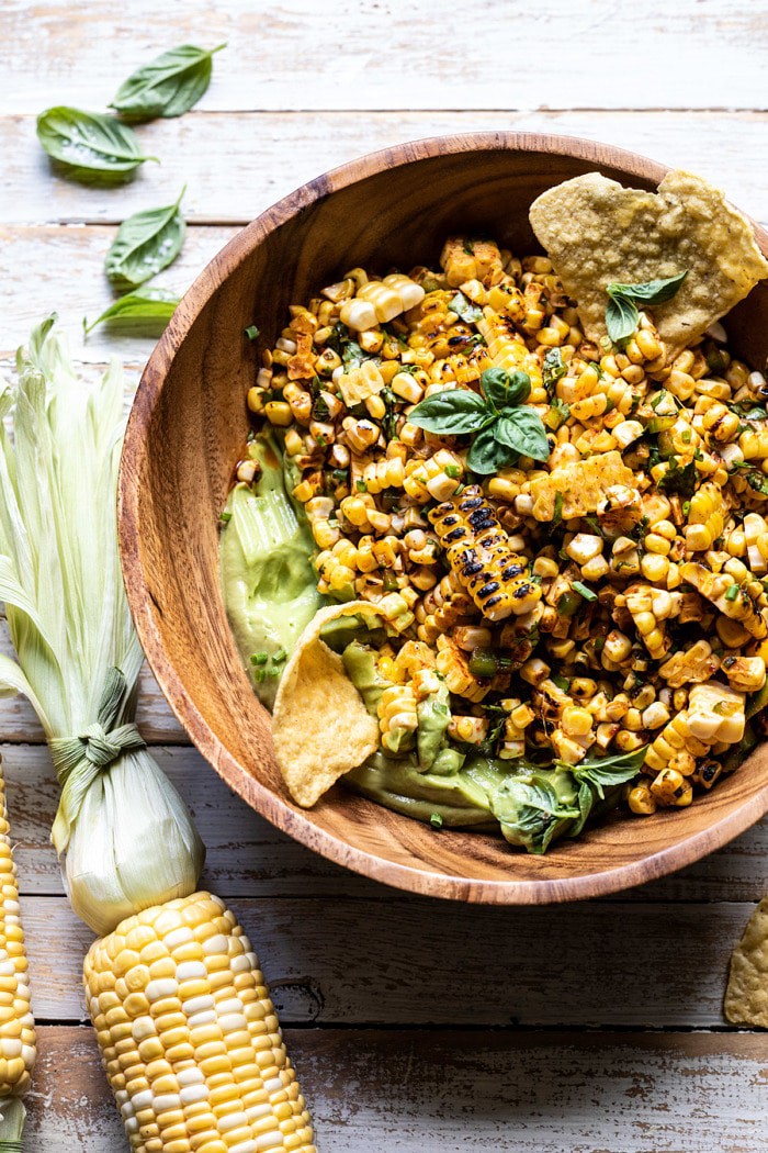 overhead photo of Grilled Street Corn Salad with Avocado Mayo in salad bowl with chips in avocado 