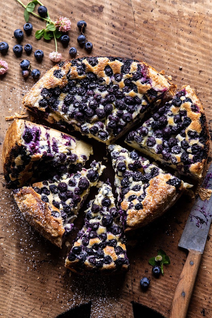 overhead photo of Simple Blueberry Basque Cheesecake with 4 slices of cake cute and berries on surface