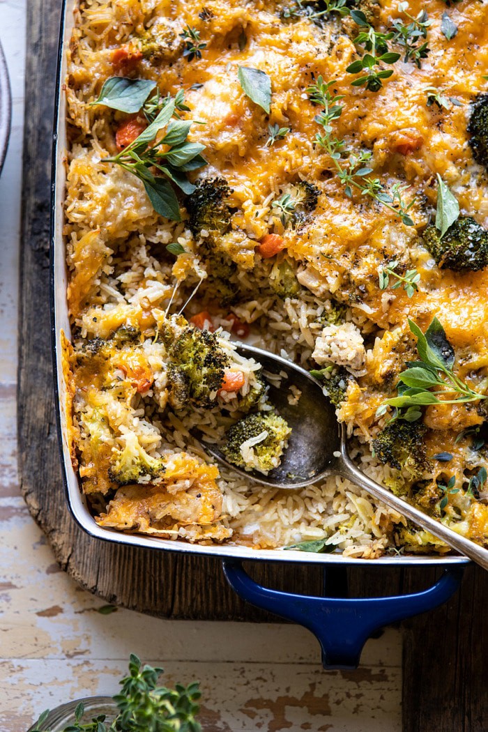 overhead close up photo of Broccoli Cheddar Chicken and Rice Casserole with serving spoon in casserole dish