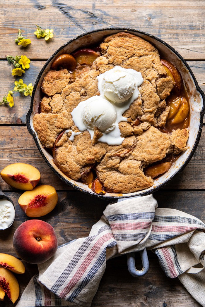 overhead photo of Skillet Brown Sugar Peach Cobbler with 2 scoops of ice cream on top