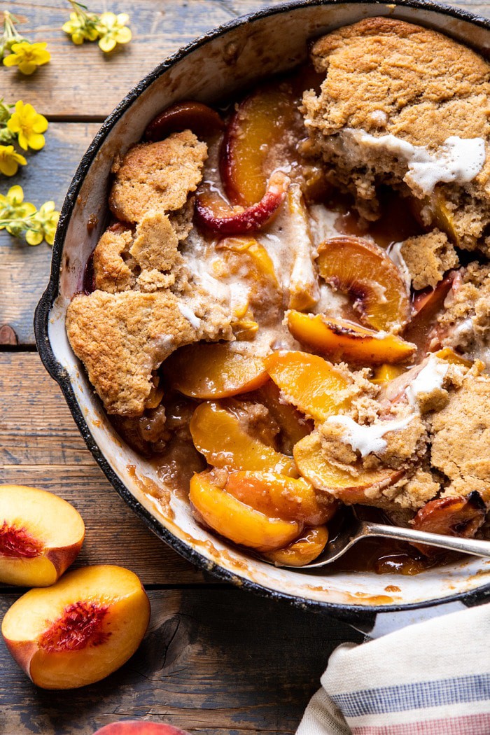 overhead close up photo of Skillet Brown Sugar Peach Cobbler with spoonfuls removed from cobbler