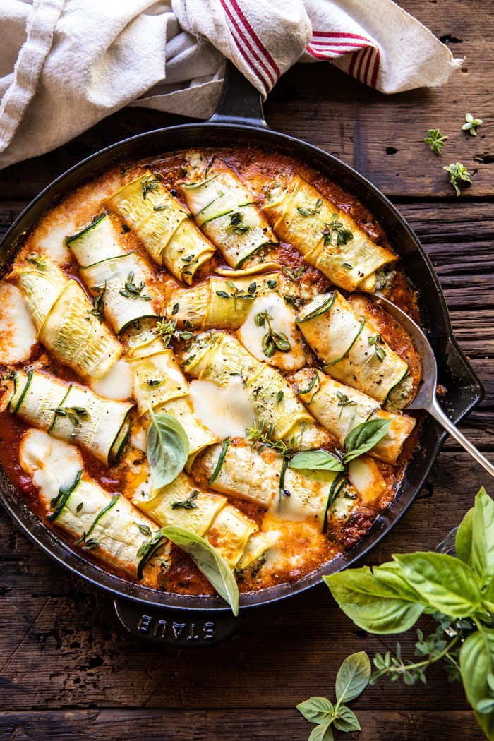 Overhead photo of Spicy Pesto and Cheese Stuffed Zucchini Involtini with spoon in skillet 