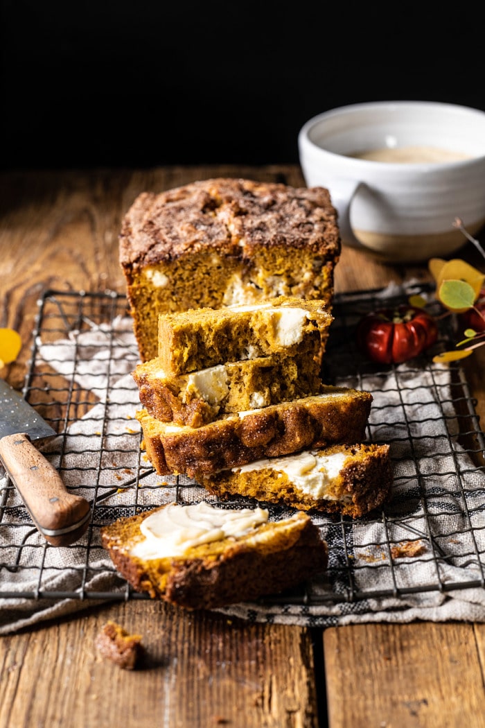 side angled photo of Cream Cheese Swirled Pumpkin Bread with multiple slices cut and stacked on top of each other