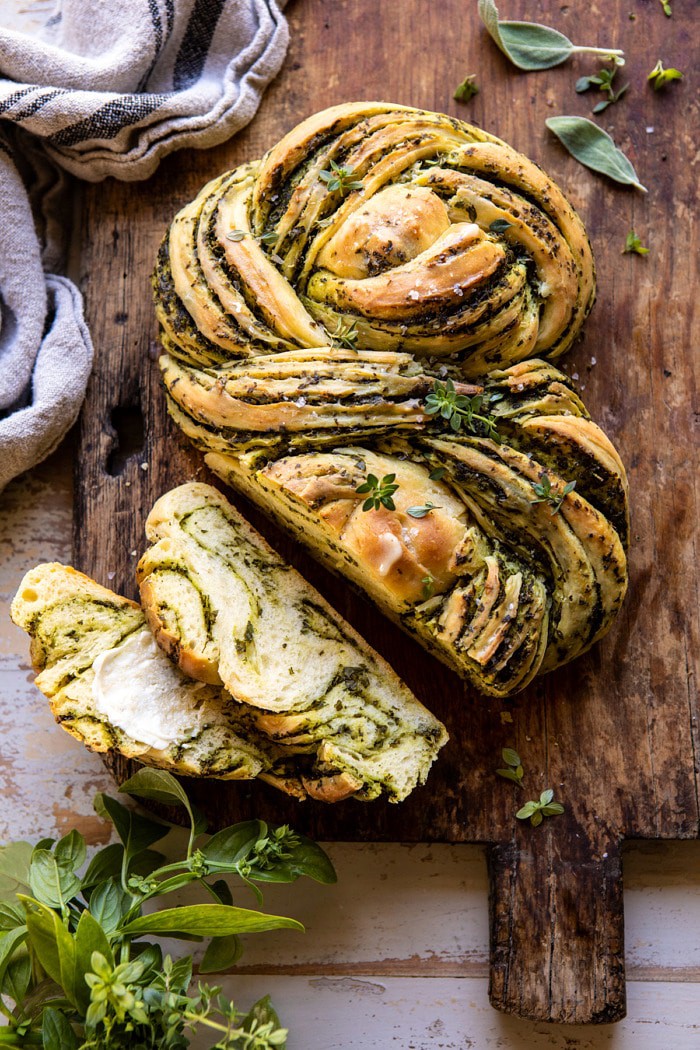 overhead photo of Swirled Garlic Herb Bread on cutting board with 2 pieces sliced
