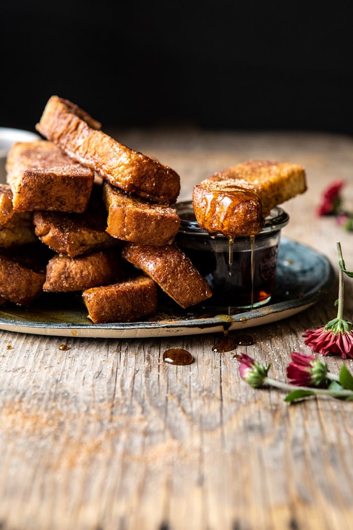 side angled photo of Cinnamon Sugar French Toast Sticks with maple syrup dripping off the french toast sticks