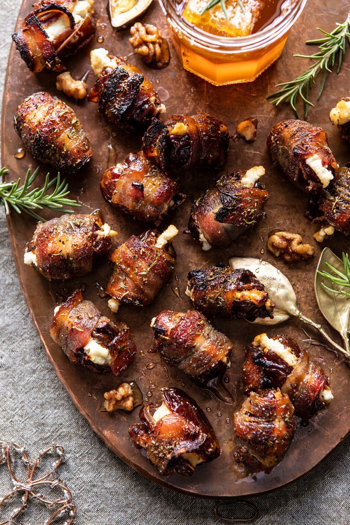 overhead photo of Goat Cheese Stuffed Bacon Wrapped Dates with Rosemary Honey with honey on tray