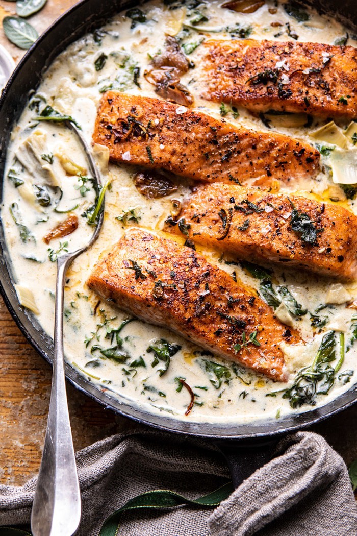 overhead close up photo of Creamy Spinach and Artichoke Salmon in skillet 