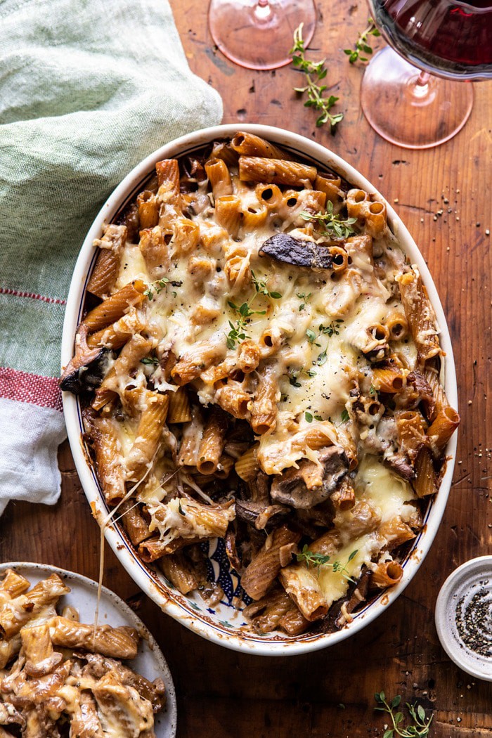 overhead photo of One Pot Creamy French Onion Pasta Bake with serving of pasta removed and sitting on a plate next to dish