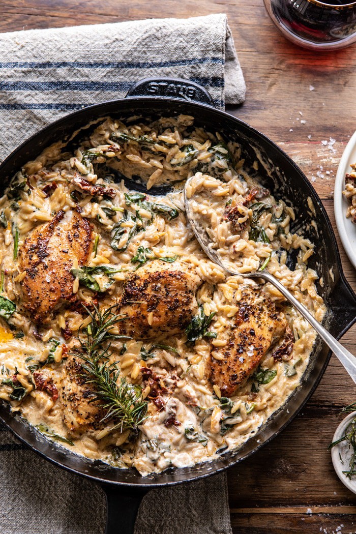 overhead photo of One Skillet Creamy Sun-Dried Tomato Chicken and Orzo with spoon in skillet 