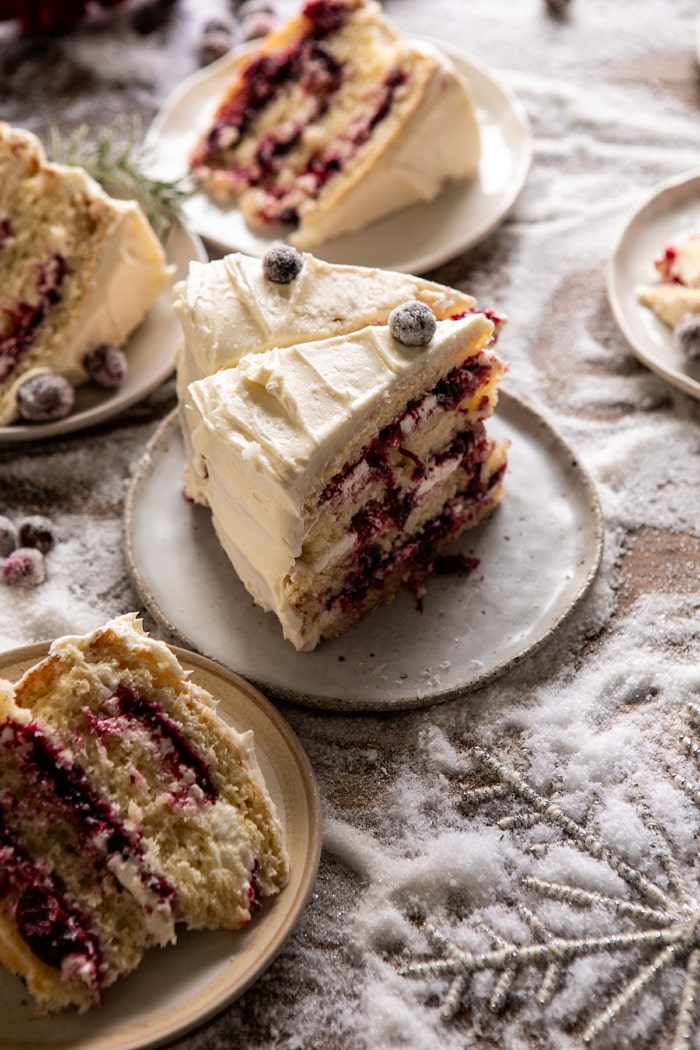 side angled photo of White Christmas Cranberry Layer Cake slices stand up on dessert plate