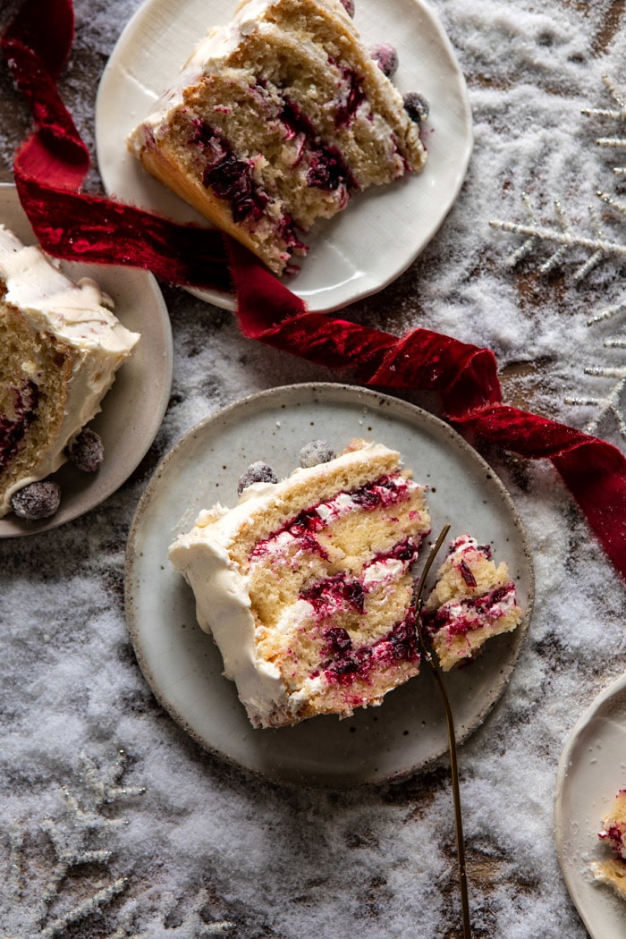 overhead close up photo of White Christmas Cranberry Layer Cake slice with fork in cake slice