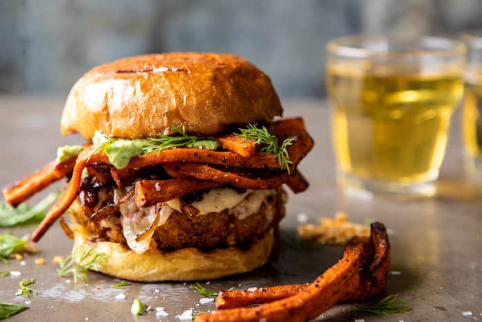 horizontal photo of Crispy Quinoa Burgers Topped with Sweet Potato Fries and Beer Caramelized Onions