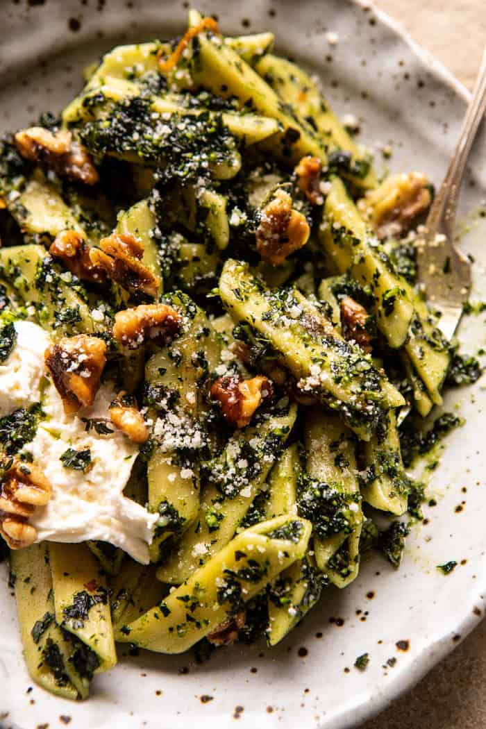 overhead close up photo of Herby Kale Pesto Pasta with Buttery Walnuts in serving bowl with fork