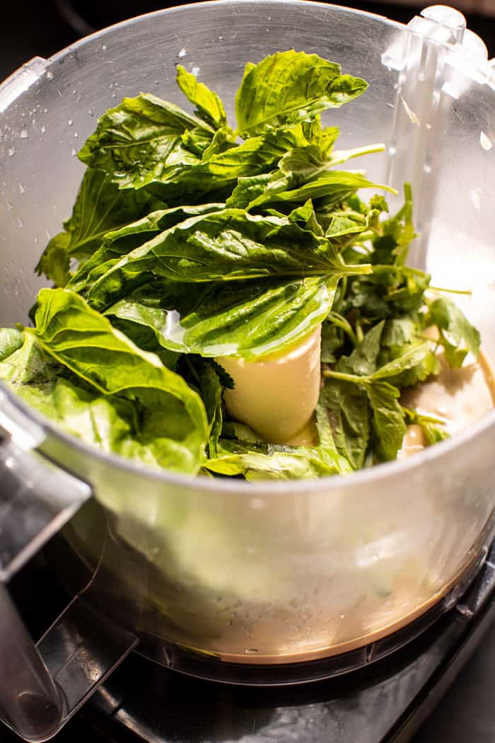 prep photo of herbs in food processor with tahini 