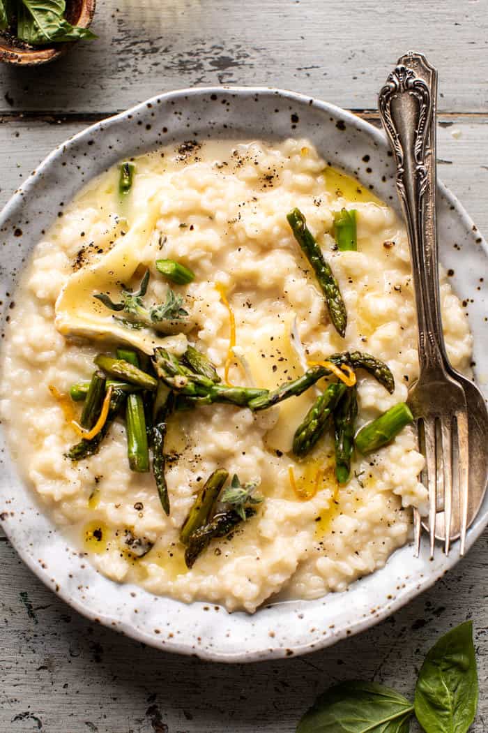overhead close up photo of No Stir Brie Risotto with Lemon Butter Asparagus and spoon in risotto bowl 