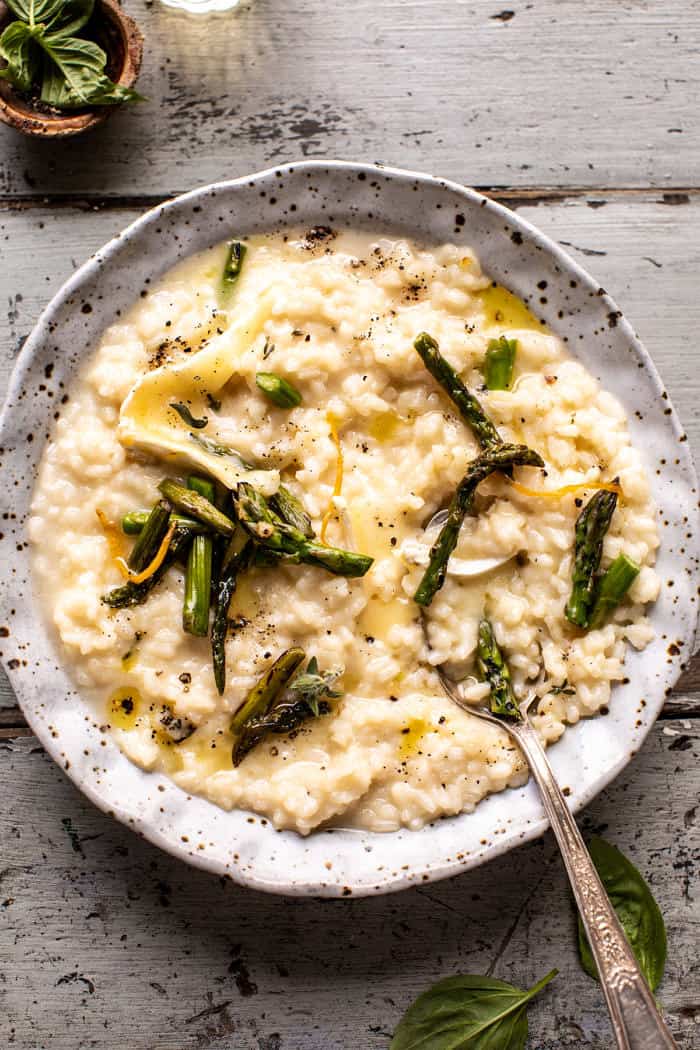 overhead photo of No Stir Brie Risotto with Lemon Butter Asparagus with spoon in bowl 