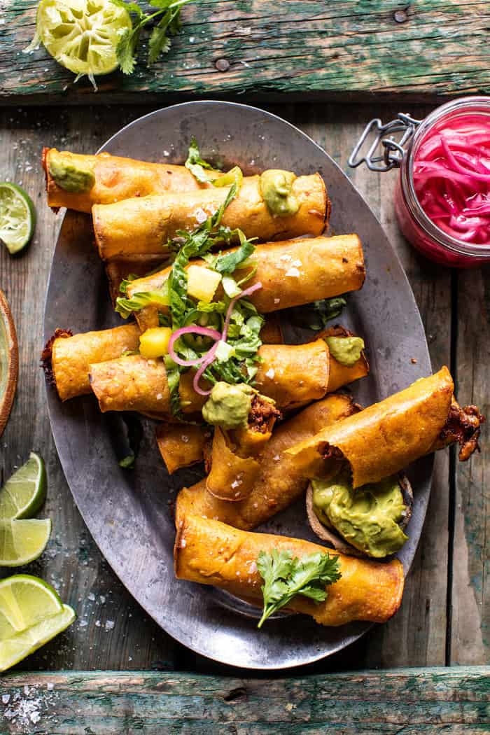 overhead photo of Crispy Chicken Tinga Taquitos with Salty Lime Avocado Crema