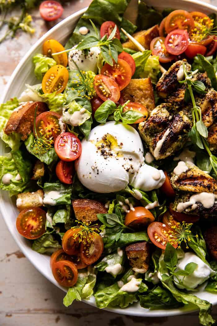 overhead close up photo of Pesto Chicken Caesar Salad with Tomatoes and Burrata