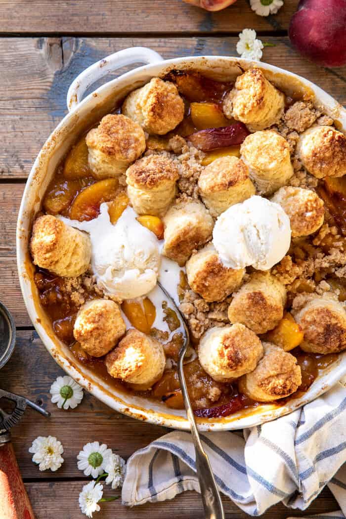 overhead close up photo of Southern Double Crusted Cinnamon Sugar Peach Cobbler with ice cream on top