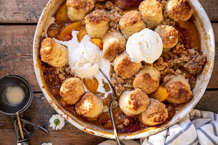 overhead horizontal photo of Southern Double Crusted Cinnamon Sugar Peach Cobbler with ice cream on top 