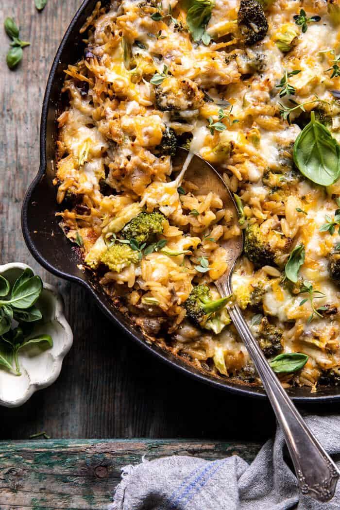 overhead close up photo of One Skillet Cheesy Broccoli Cheddar Orzo Bake with spoon in skillet 