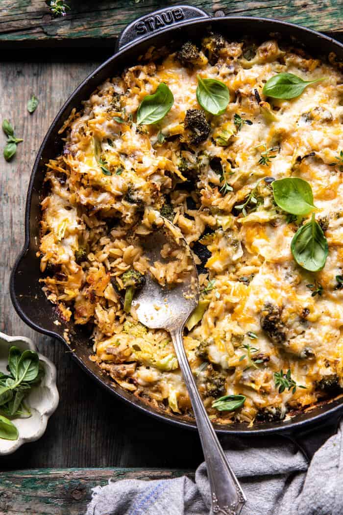 overhead photo of One Skillet Cheesy Broccoli Cheddar Orzo Bake with spoon in skillet 