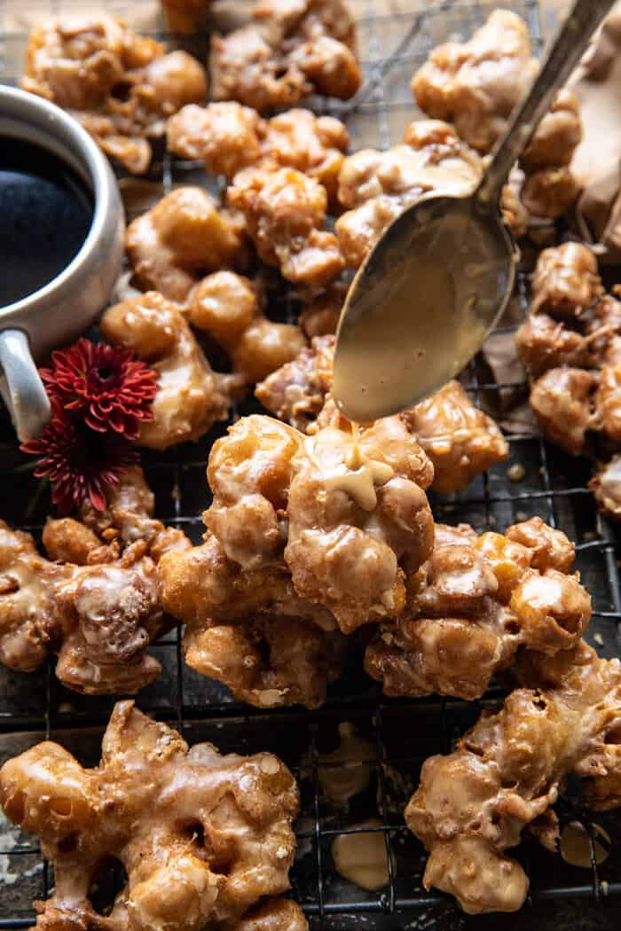 photo of Cinnamon Spiced Apple Fritters with Vanilla Coffee Glaze being drizzle over each fritter
