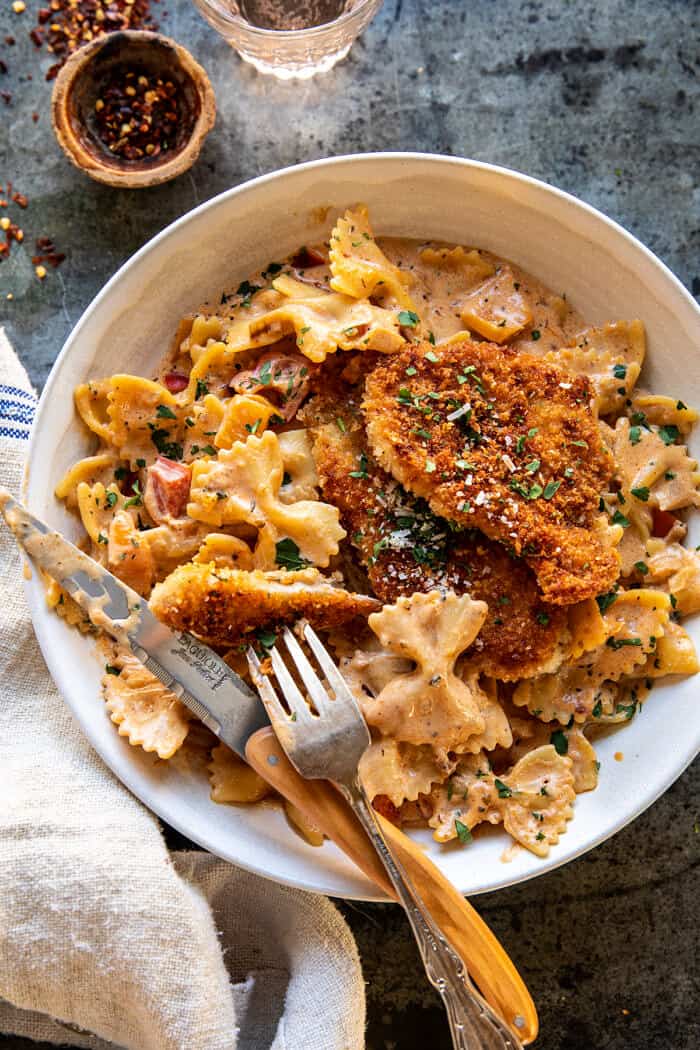 overhead photo of Southern Style Creamy Parmesan Chicken Pasta with fork and knife in bowl 